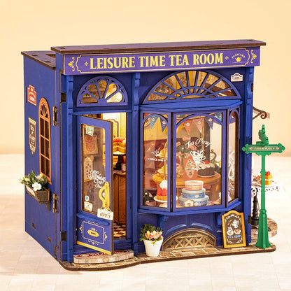 Miniature blue tea shop model with 'Leisure Time Tea Room' sign and bakery display window