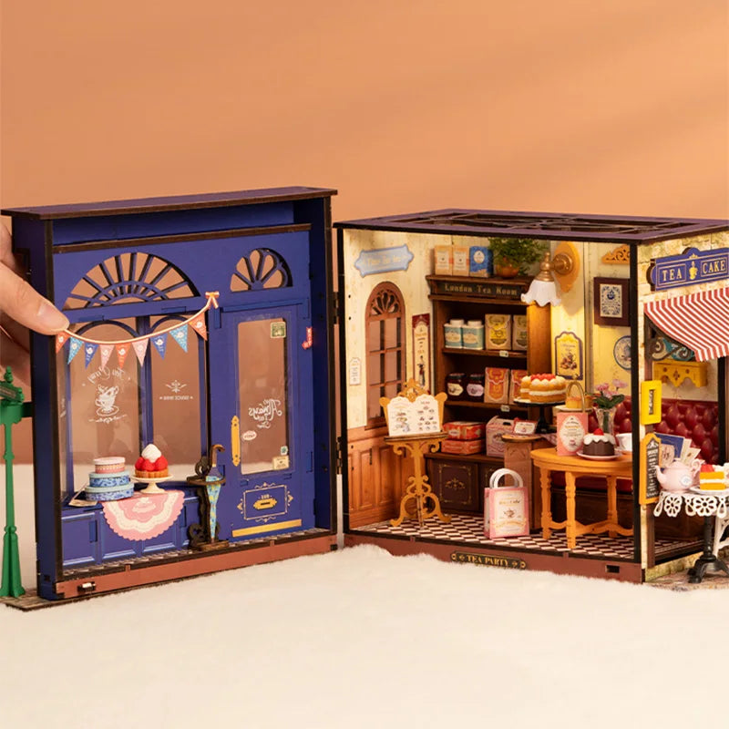 Miniature blue tea shop model with detailed interior, bakery displays, and vintage decor