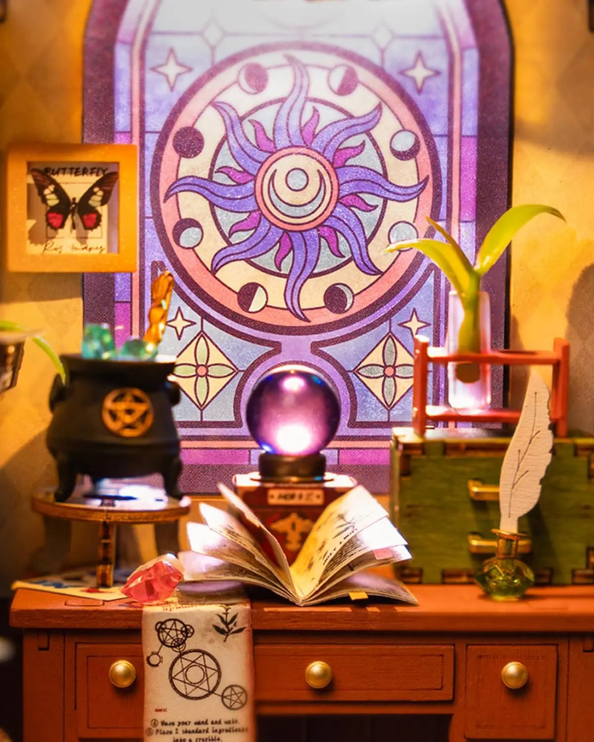 Miniature witch desk with spell book, cauldron, crystal ball, feather quill, and stained glass window